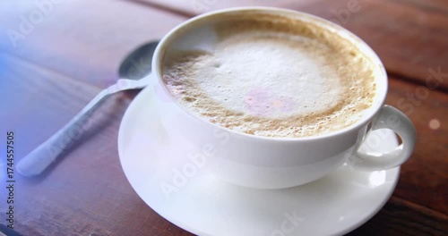 On start camera moving into close-up, highlighting white coffee cup with foam on table