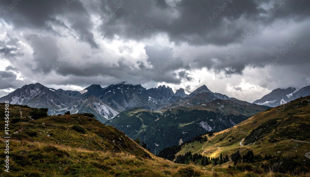 Fototapeta premium Dramatic Mountain Range Landscape with Stormy Sky and Grassy Hills in Sunlight