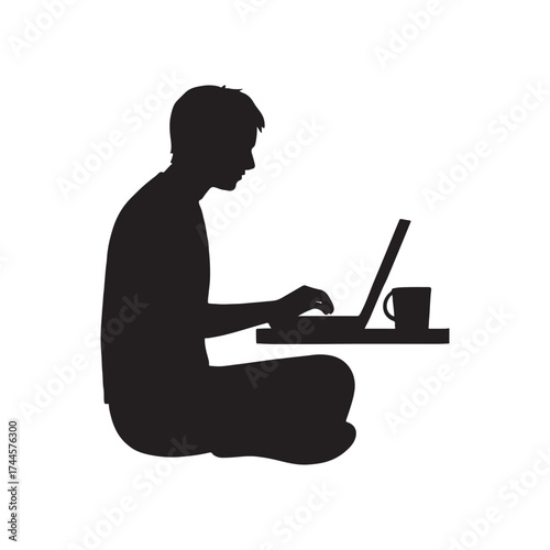 Silhouette of a person working on a laptop while sitting cross legged on the floor enjoying a cup of coffee representing modern remote work flexibility and digital nomad lifestyle
