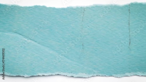 Ripped turquoise paper fragment with frayed edges