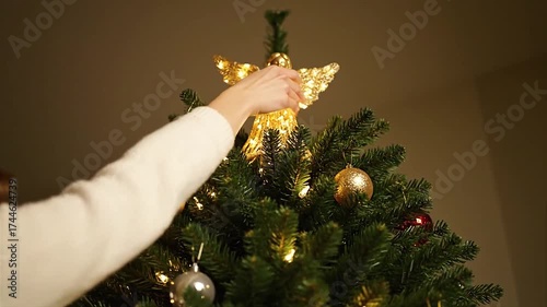 Woman Decorating Christmas Tree with Ornaments and Angel Topper