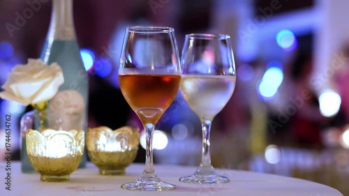 Wine on a table during a wedding reception or party with people dancing and having fun in the background. 