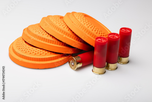 Clay shooting targets with shotgun shell bullets on white background