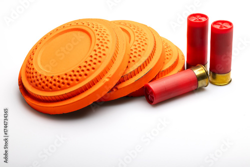 Clay shooting targets with shotgun shell bullets on white background