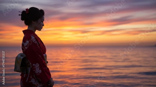 Woman in traditional attire silhouette against ocean sunset
