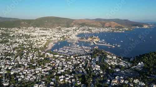 Bodrum, Turkey : Forward aerial drone footage of marina and castle in Bodrum, popular beach holiday destination in Turkey. With mountains in the background on sunny day