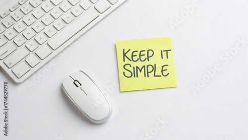 White Computer Mouse and Keyboard with a Yellow Sticky Note that Says Keep It Simple on a Light Background