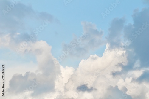 A mix of dark grey storm clouds and bright white cumulus formations against a pale blue sky, showing the transition of weather and dramatic atmospheric contrast.