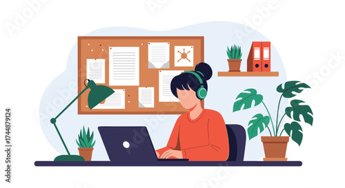 A woman studying and working on a laptop at her desk with plants and a corkboard.