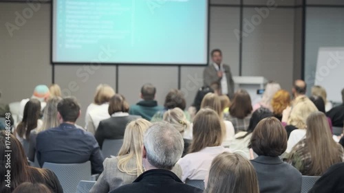 Wallpaper Mural Professional speaker delivers presentation to engaged audience in a conference setting, highlighting learning and collaboration in a modern seminar hall. Torontodigital.ca
