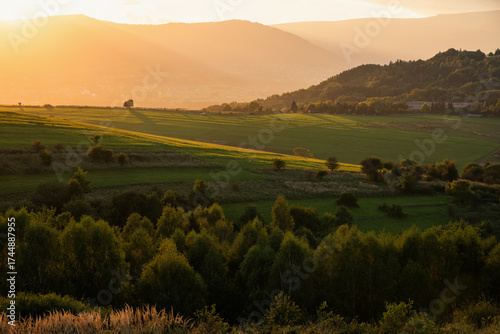 Fototapeta Naklejka Na Ścianę i Meble -  Piękny zachód słońca nad Beskidami, z ciepłym światłem oświetlającym wzgórza i doliny. 