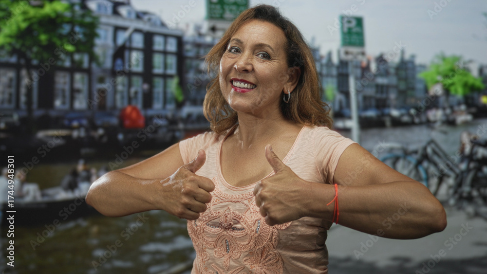 Fototapeta premium Middle aged hispanic woman gives double thumbs up gesture on street; confidence encouragement optimism.
