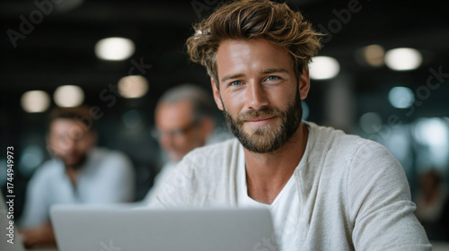 Young man smiling while working on a laptop at home