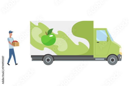 A truck driver loads boxes of apple juice into a truck. A man holds a basket of apples by a green delivery truck