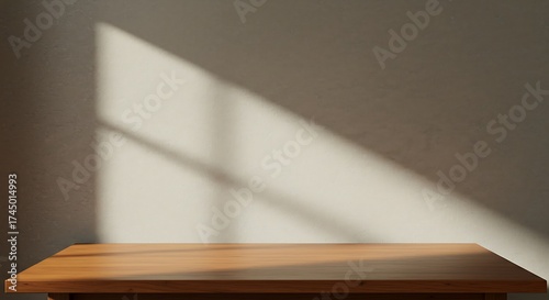 Minimalist scene featuring an empty wooden table and a wall illuminated by natural sunlight casting distinct window shadows.