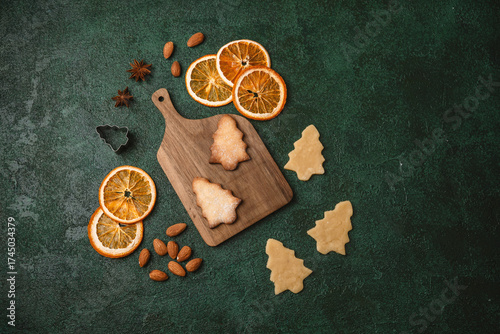 Christmas tree cookies with raw dough and wooden board for holiday food styling and festive background concept