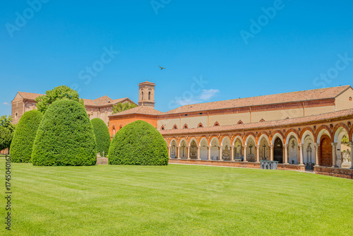 Saint Christopher church rising within the Charterhouse of Ferrara, its warm brick facade glowing under a vibrant blue sky, creates a serene scene of architectural beauty in Ferrara city of Italy
