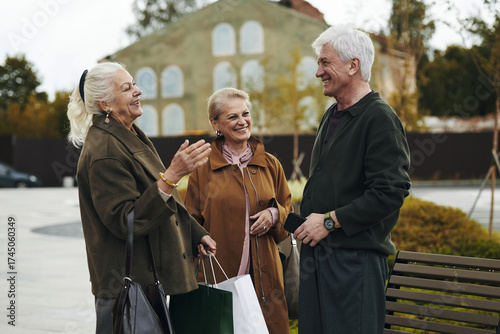 Slika na platnu Group of two senior Caucasian women and one man standing outdoors smiling and ta