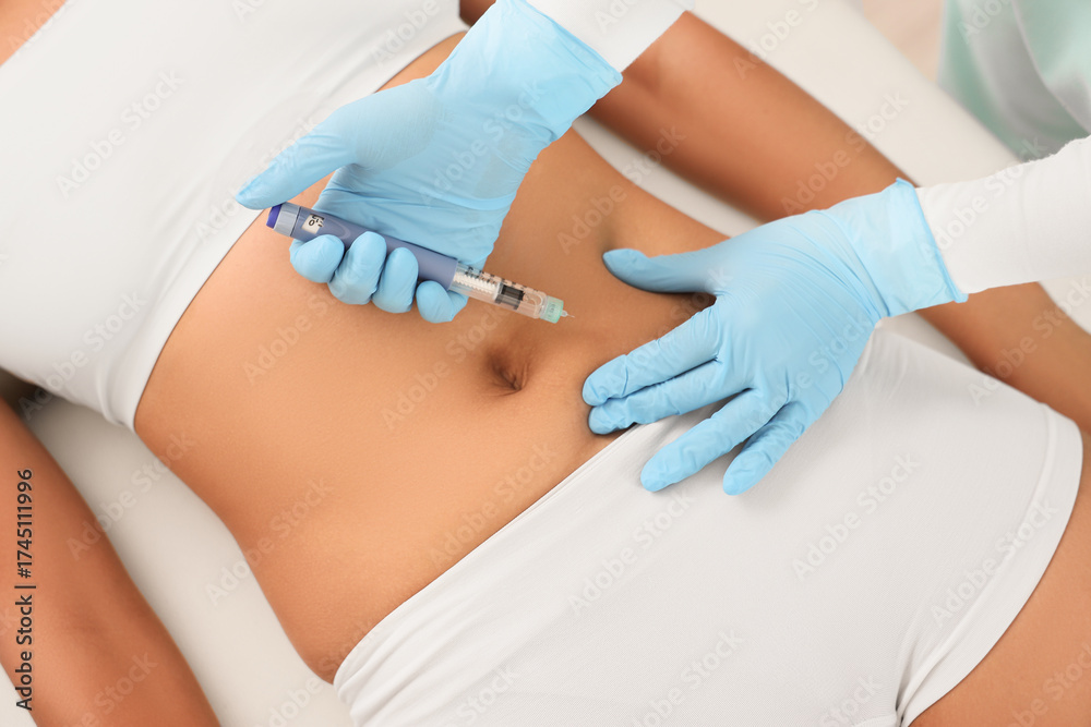 Fototapeta premium Doctor injecting woman on couch, top view. Weight loss concept