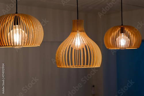 Foto Modern wooden pendant ceiling lamps glowing with warm light bulbs interior decor