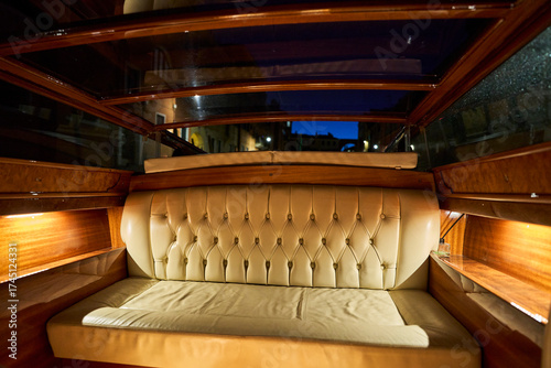 Luxurious leather seating inside a wooden boat.