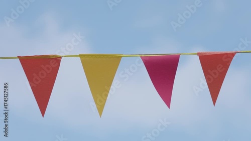 Experience the captivating beauty of colorful triangular flags fluttering in the gentle breeze against a pristine blue sky, evoking feelings of joy and celebration all around.