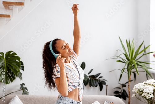 Young woman dancing and listening to music with headphones