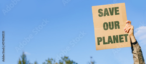Activist Male hand up, holds a Save the Planet on nature and blue sky background. Environmental concerns. Ecology Protest.
