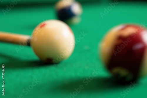 Blurred Billiard balls on green table with billiard cue. Snooker, pool game