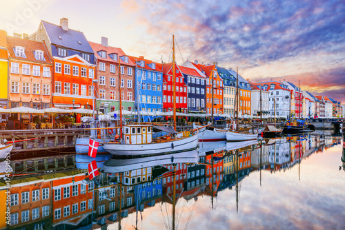 Copenhagen, Denmark. Nyhavn waterfront, colourful buliding facades and old ships along the canal.