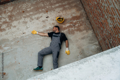 Slika na platnu Man, construction worker fell from big height, lying down without consciousness,