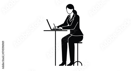 A woman seated on a stool working on a laptop at a table