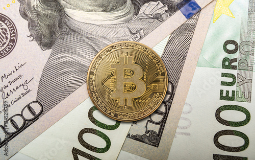Bitcoin coin placed on top of dollar bills and euro notes in a financial exchange setting