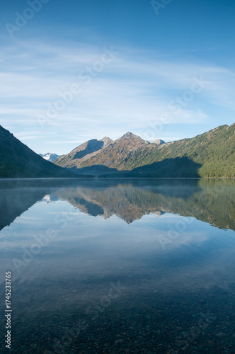Morning view of Lower Multinskoye lake with Altai mountains mirroring in its water in the background, Russian Federation