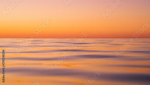 Vibrant sunset over calm ocean water with soft waves and colorful sky