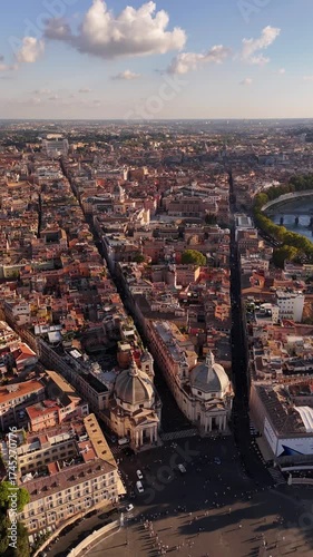 Aerial drone footage over Rome showcasing Piazza del Popolo with twin baroque churches Santa Maria in Montesanto and Santa Maria dei Miracoli, iconic cinematic landmark of Italian heritage