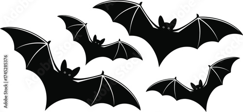 Group of stylized bats in flight black silhouettes on white background