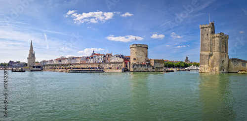 Panoramic view of the iconic entrance to the Vieux Port of La Rochelle, France. Panorama of all three medieval towers guarding the marina, the Tour Saint-Nicolas near the chain and the lantern towers