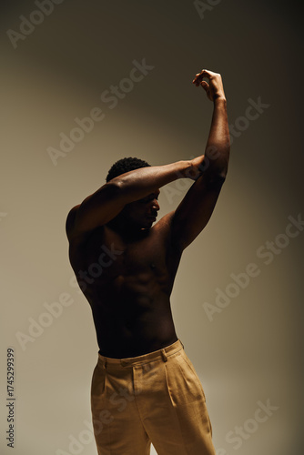 Fotografie Dynamic pose of a strong African American man in a studio setting