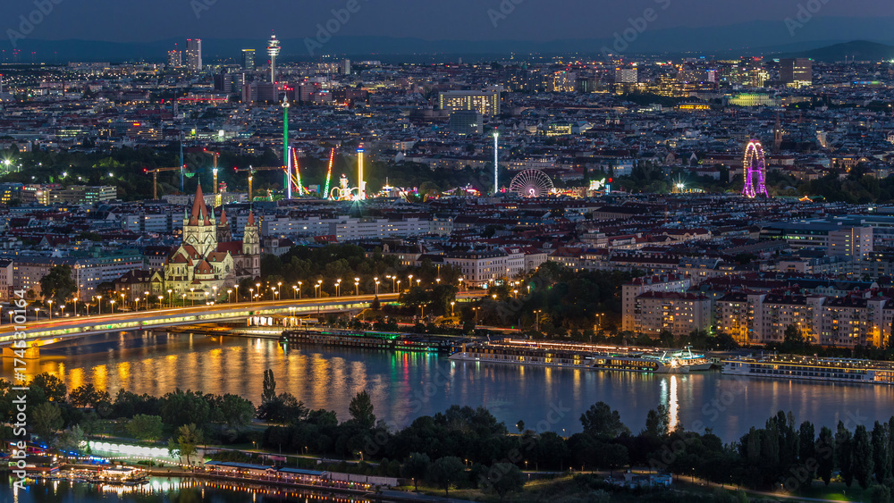 Obraz premium Aerial panoramic view over Vienna city with skyscrapers, historic buildings and a riverside promenade day to night timelapse in Austria.