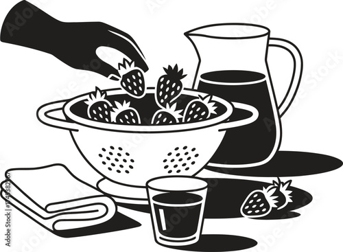 Hand placing fresh strawberries into a colander with juice and towel nearby