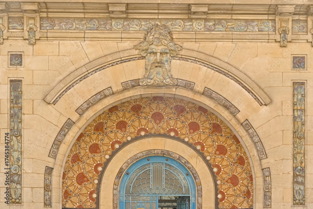 Obraz premium Art deco decoration with mosaic abstract patterns and sculpted face of the entrance of the Saint Georges swimming pool of Rennes, France 