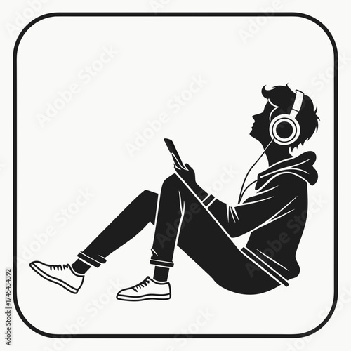 Silhouette of a young person wearing headphones and holding a smartphone while sitting down