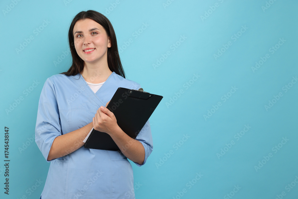 Obraz premium Nurse with clipboard on light blue background, space for text