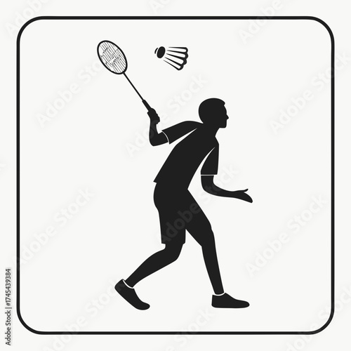 Silhouette of a male badminton player in action hitting a shuttlecock with a racket during a match