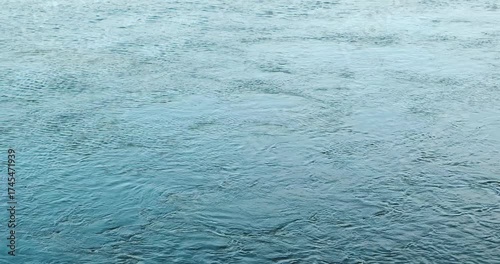 The river's flowing water is a deep blue, without ripples or waves. It's calm and soothing, creating an atmosphere of serenity like the blue background.