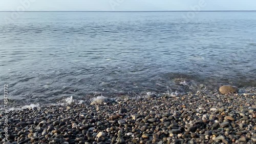 Rocky shoreline with a body of water in the background. The water is calm and clear