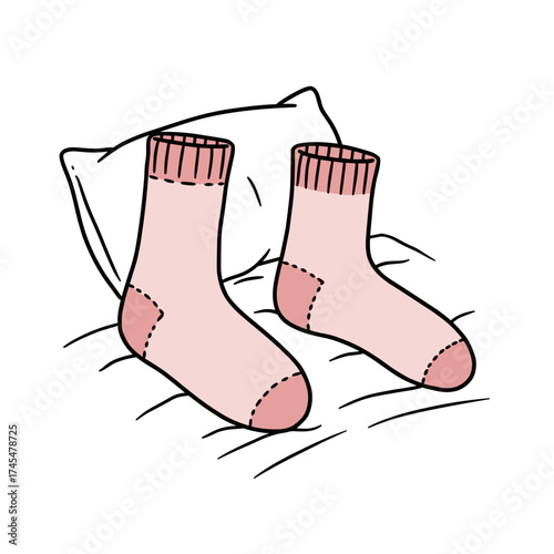 Pink socks resting on a pillow in a cozy bedroom setting  