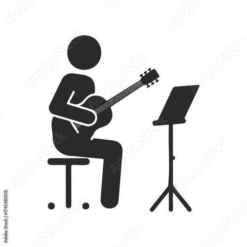 Silhouette of person playing guitar with music stand
