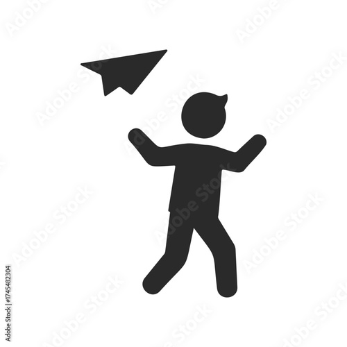Silhouette of a person throwing a paper airplane in playful gesture